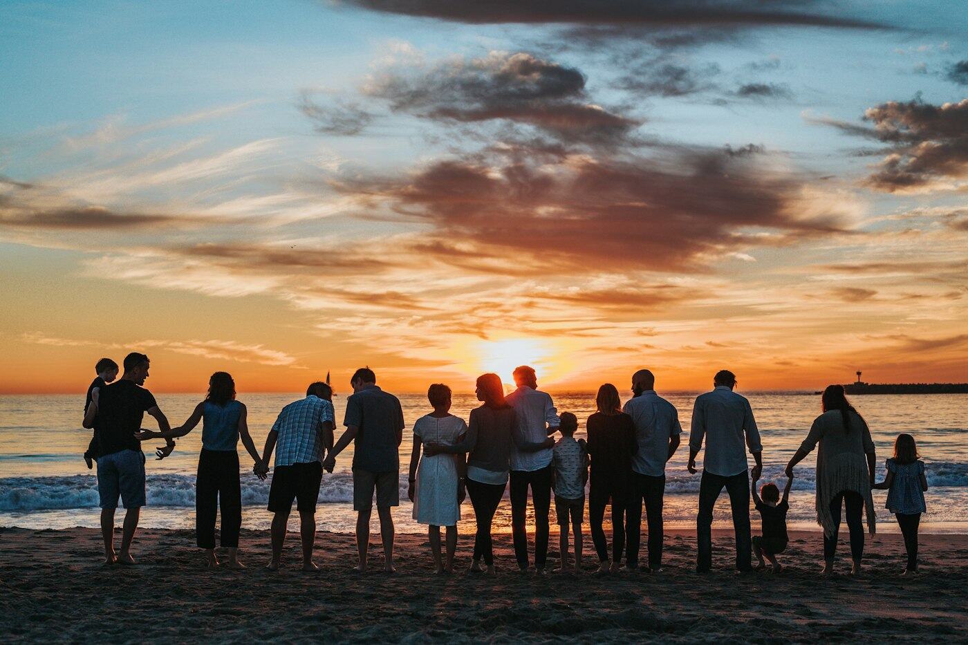 Família reunida na praia ao pôr do sol